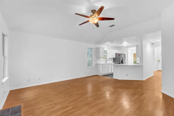 a view of kitchen with wooden floor and a refrigerator
