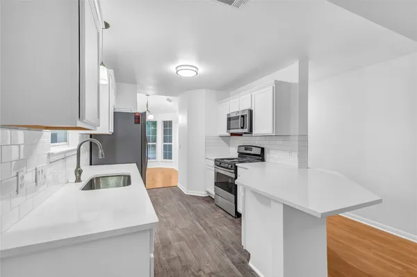 a kitchen with granite countertop a sink stove and cabinets