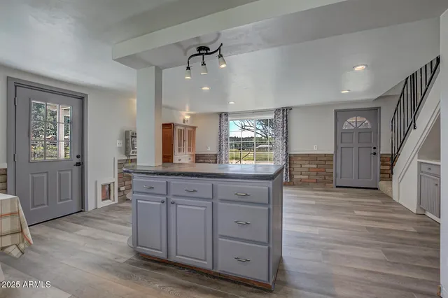 a kitchen with stainless steel appliances white cabinets and wooden floors