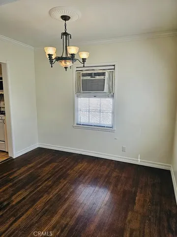 a view of a room with wooden floor a ceiling fan and windows