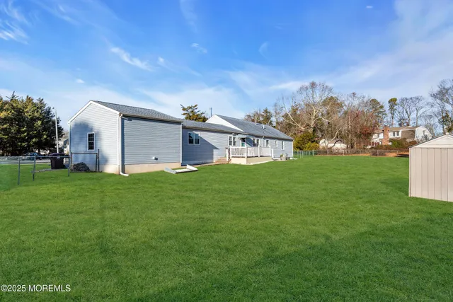 a view of a house with a big yard and large trees