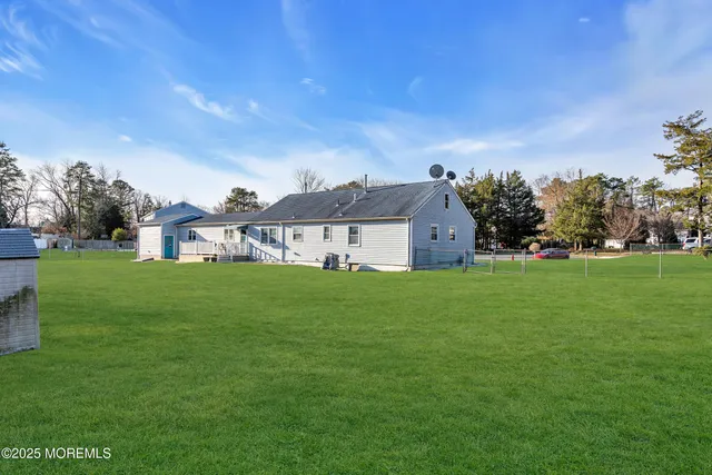 a view of a green field with trees in the background