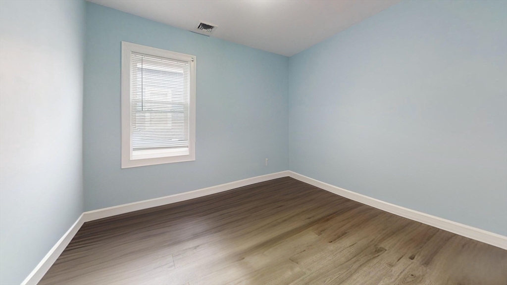 346 Cherry Street, Unit 2 Newton, MA 02465 - Photo 4 of 12 an empty room with wooden floor and windows