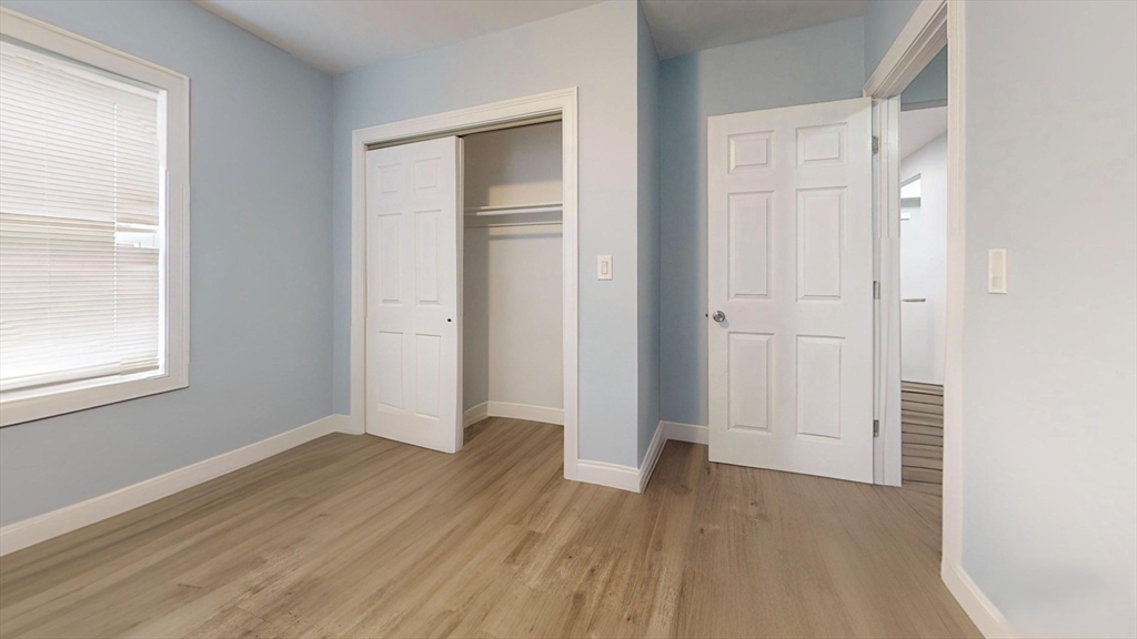 346 Cherry Street, Unit 2 Newton, MA 02465 - Photo 8 of 12 an empty room with wooden floor and windows