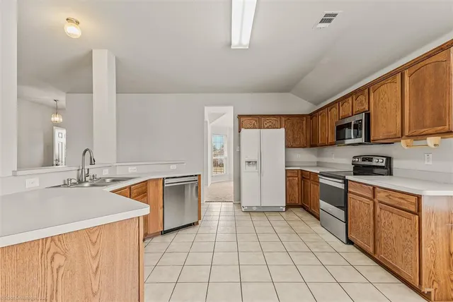 a kitchen with stainless steel appliances granite countertop a sink stove and cabinets