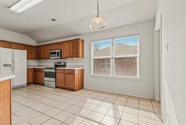 a kitchen with a refrigerator a stove top oven a sink dishwasher and a refrigerator