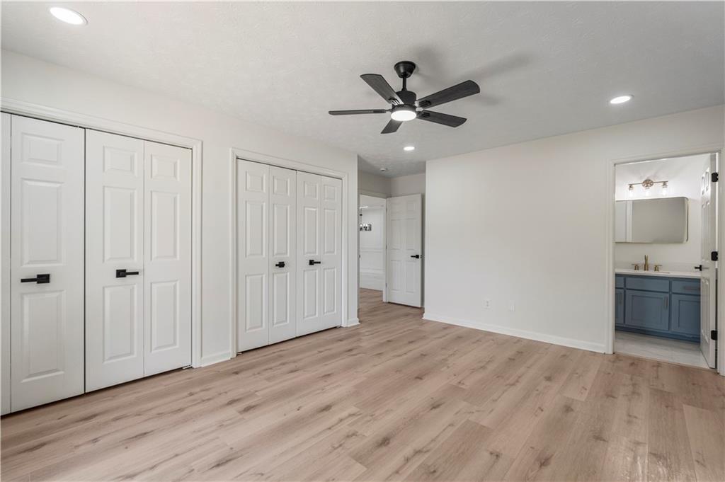 766 Lee Road Phenix City, AL 36870 - Photo 13 of 30 Unfurnished bedroom featuring two closets, light wood finished floors, connected bathroom, recessed lighting, and a ceiling fan