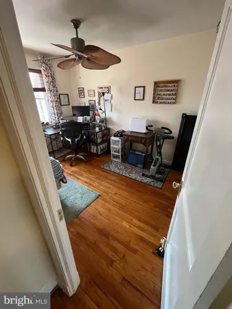 a view of a workspace with furniture and wooden floor