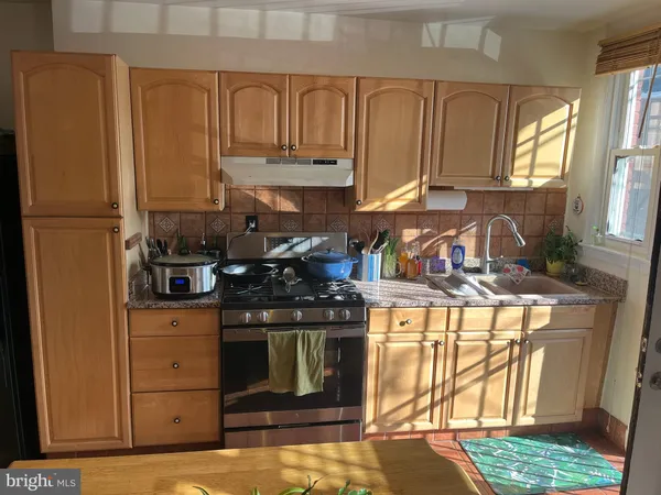a living room with stainless steel appliances furniture a flat screen tv and a rug
