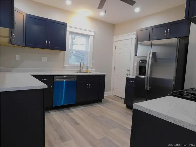 a kitchen with stainless steel appliances granite countertop a refrigerator a sink and dishwasher