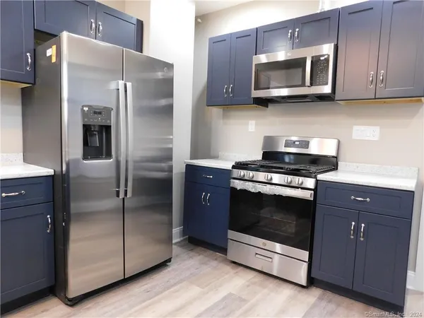 a kitchen with stainless steel appliances granite countertop a refrigerator stove and microwave