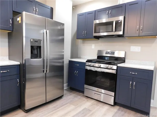 a kitchen with stainless steel appliances granite countertop a refrigerator stove and microwave