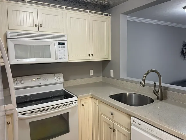 a kitchen with white cabinets and white appliances