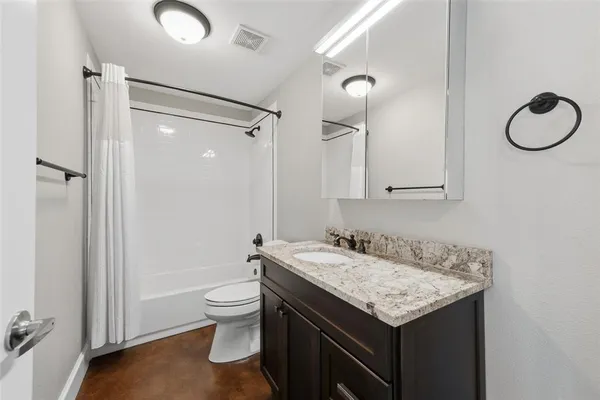 a bathroom with a granite countertop sink toilet and shower