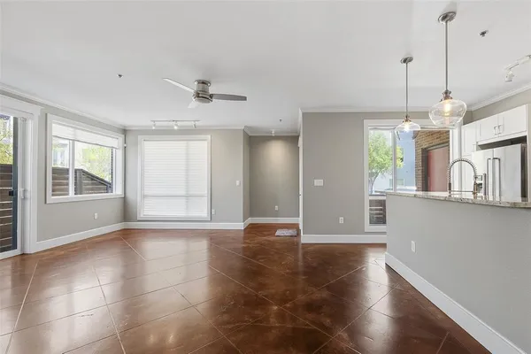a view of an empty room with window and wooden floor