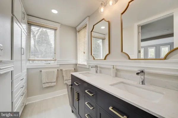 a bathroom with a double vanity sink a mirror and a bathtub