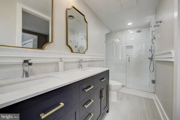 a bathroom with a double vanity sink mirror double and shower