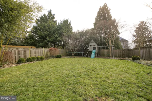 a backyard of a house with childrens swings and slides