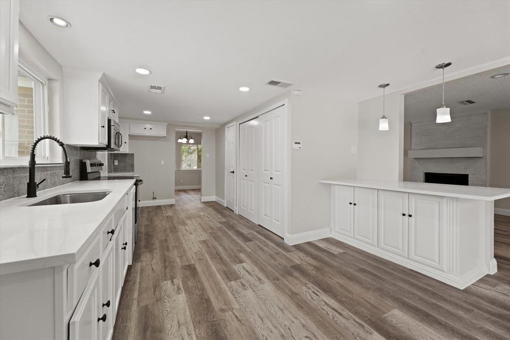 a kitchen with white cabinets appliances and sink