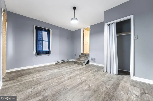 an empty room with window and a ceiling fan