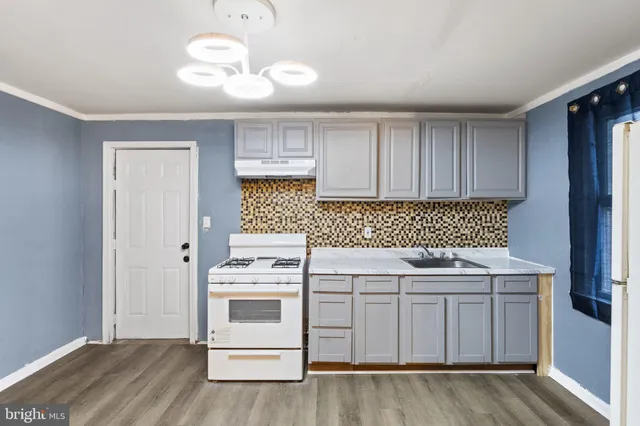 a kitchen with a stove sink and cabinets
