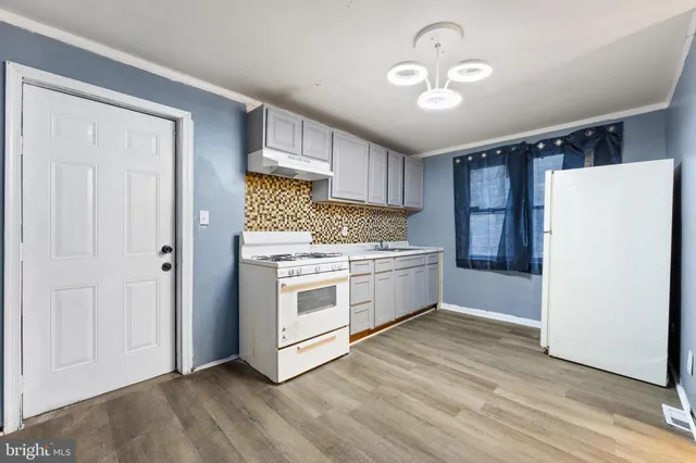 a kitchen with a white refrigerator and a stove top oven