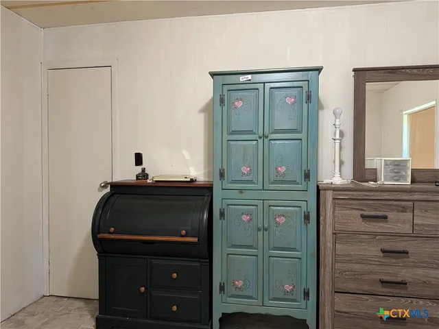 a bedroom with a dresser and a mirror