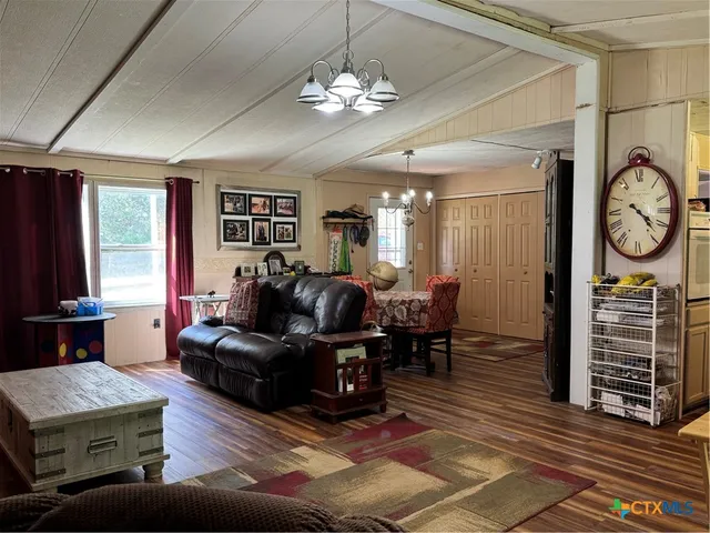 a living room with furniture a fireplace and a chandelier