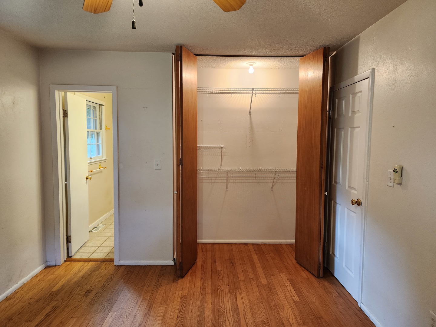 1825 Crescent Drive Champaign, IL 61821 - Photo 12 of 24 a view of an empty room with wooden floor and a bathroom
