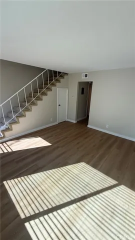 a view of a hallway with wooden floor and staircase