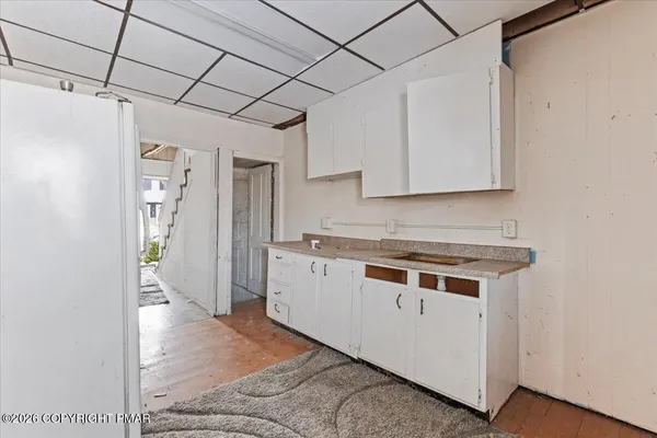 a view of a room with wooden floor and furniture