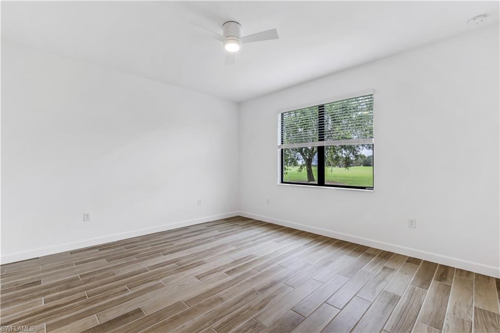 1817 Lema Court Naples, FL 34120 - Photo 14 of 22 wooden floor in an empty room with a window