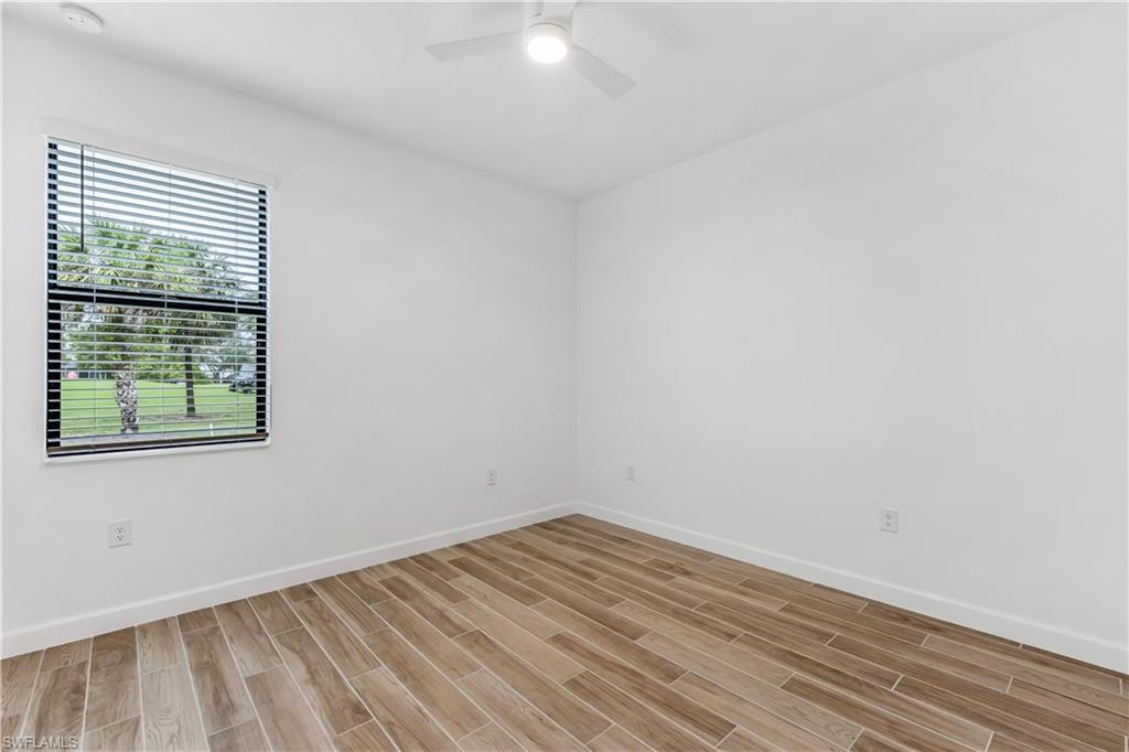 1817 Lema Court Naples, FL 34120 - Photo 18 of 22 an empty room with wooden floor and windows