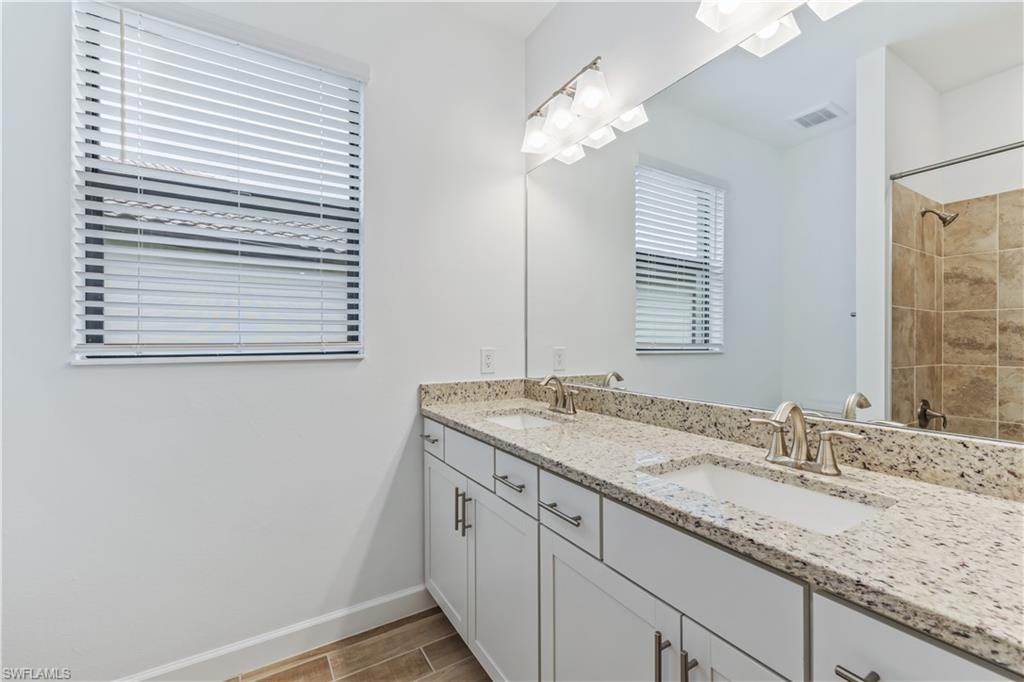 1817 Lema Court Naples, FL 34120 - Photo 19 of 22 a bathroom with a granite countertop sink and a mirror