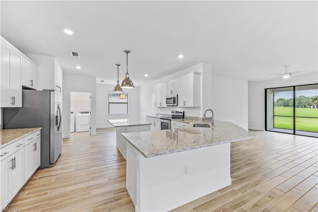 1817 Lema Court Naples, FL 34120 - Photo 2 of 22 a large kitchen with stainless steel appliances kitchen island a large counter top and a wooden floors