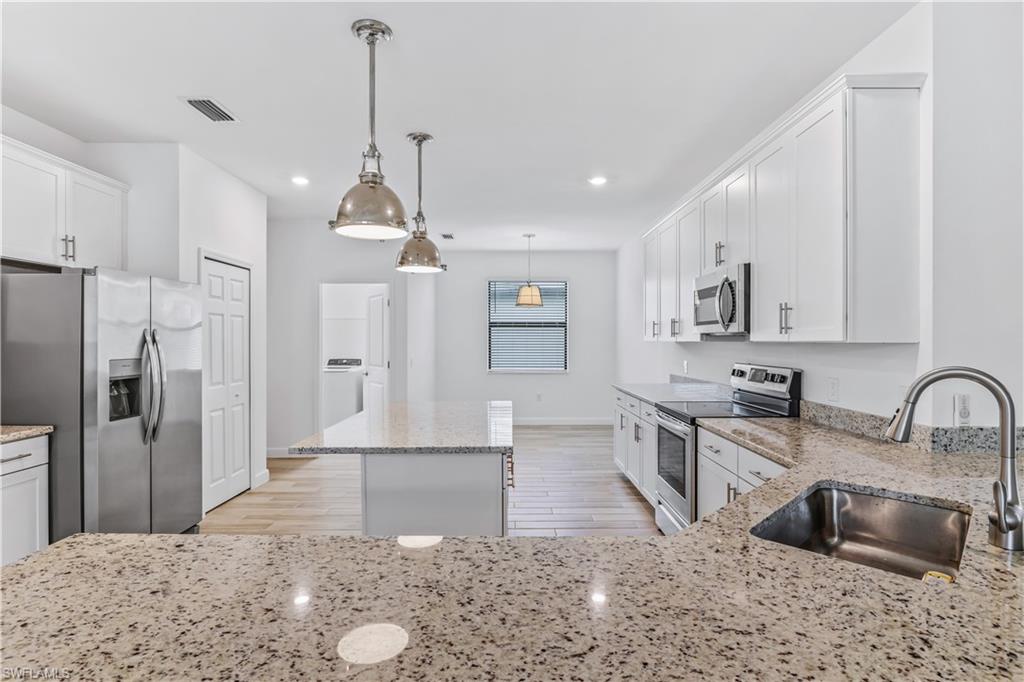 1817 Lema Court Naples, FL 34120 - Photo 4 of 22 a kitchen with stainless steel appliances granite countertop a sink refrigerator stove and microwave