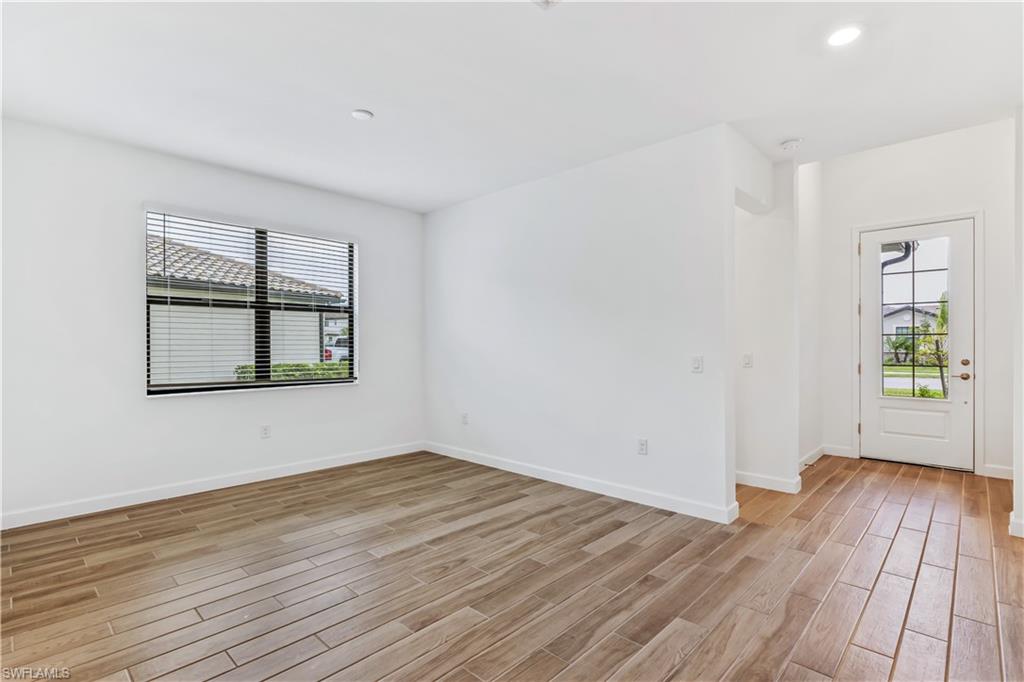 1817 Lema Court Naples, FL 34120 - Photo 5 of 22 wooden floor in an empty room with a window