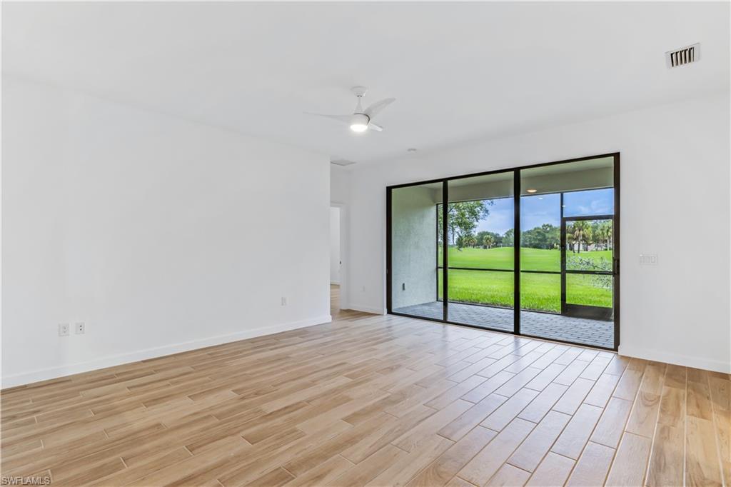 1817 Lema Court Naples, FL 34120 - Photo 8 of 22 a view of an empty room with wooden floor and a window