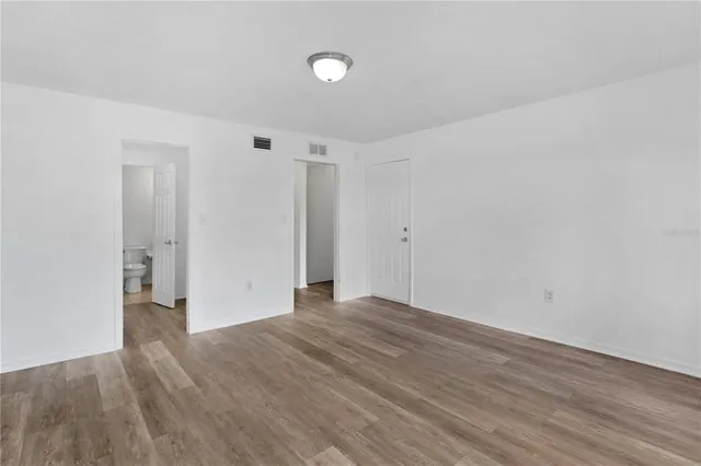 a view of an empty room with wooden floor