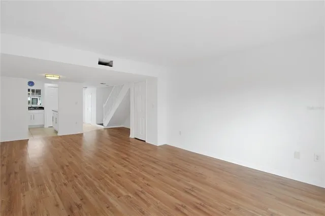 a view of empty room with wooden floor and windows