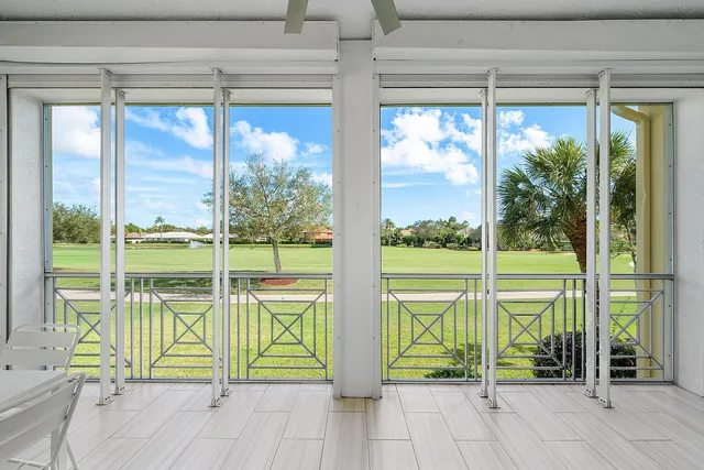 a view of a white house with a big yard and potted plants