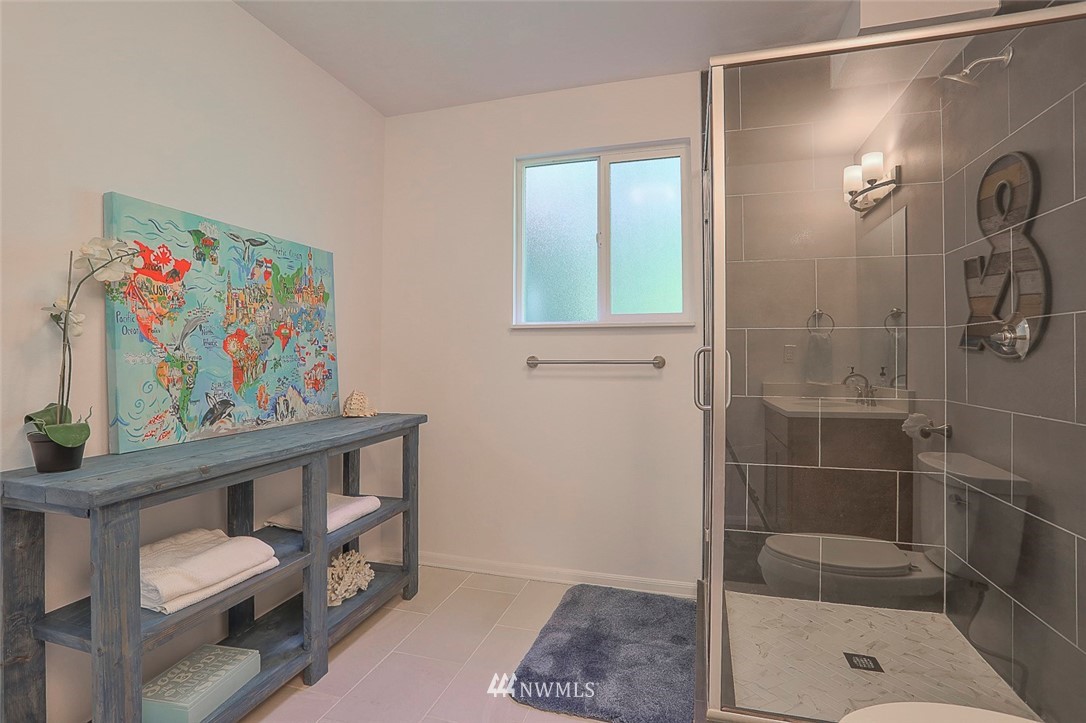 21314 2nd Avenue Southeast Bothell, WA 98021 - Photo 23 of 25 a bathroom with a painting on the wall and a shower