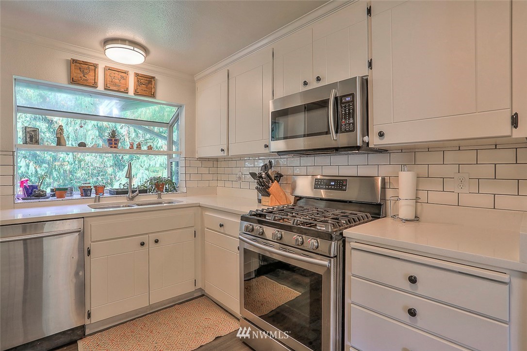 21314 2nd Avenue Southeast Bothell, WA 98021 - Photo 9 of 25 a kitchen with white cabinets stainless steel appliances and a sink