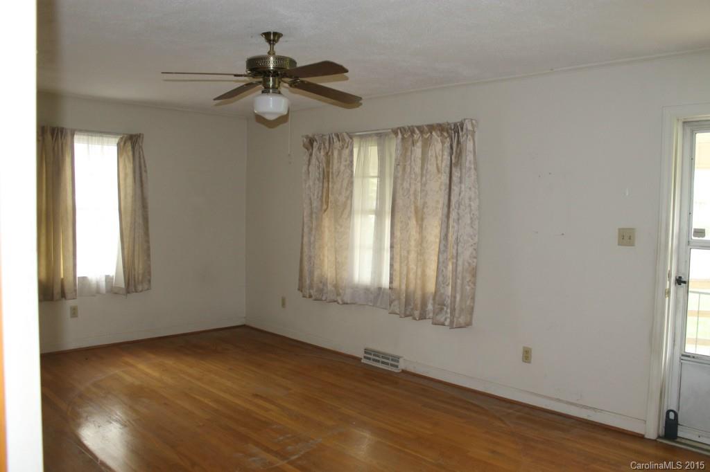 116 Terrace Road Mooresville, NC 28117 - Photo 7 of 12 an empty room with wooden floor fan and windows