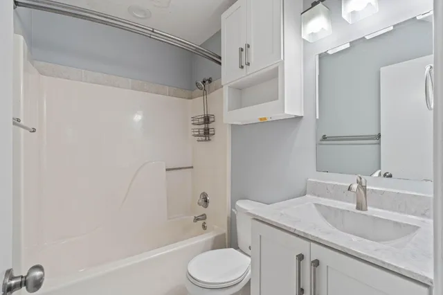a bathroom with a granite countertop sink toilet and shower