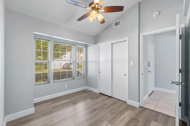 a view of an empty room with window and wooden floor