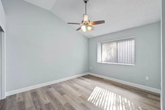 a view of wooden floor and chandelier fan in a room
