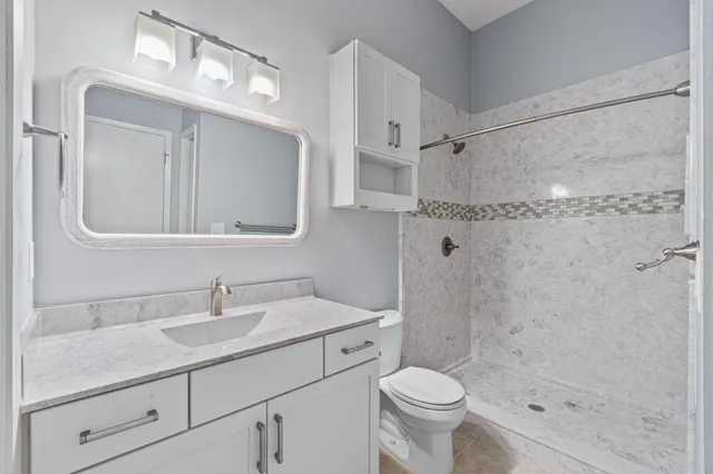 a bathroom with a sink a toilet and shower