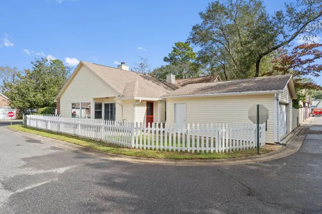 a view of a house with a small yard and fence