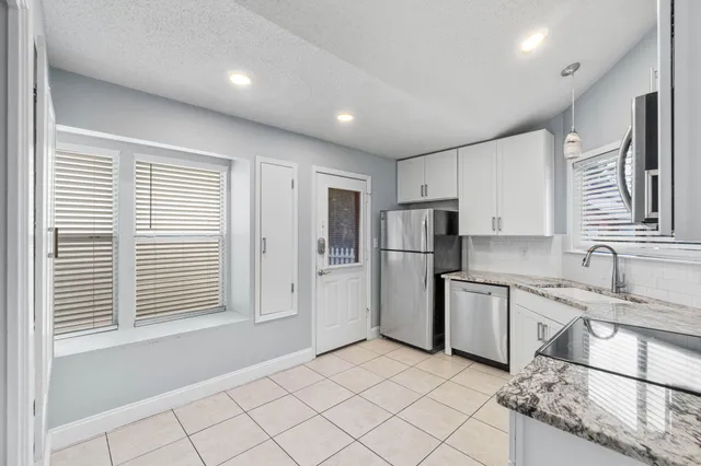 a kitchen with refrigerator and cabinets